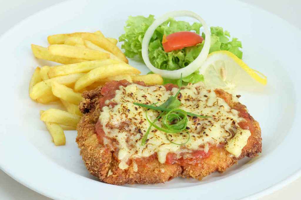 piatto con cotoletta alla valdostana con contorno di patatine