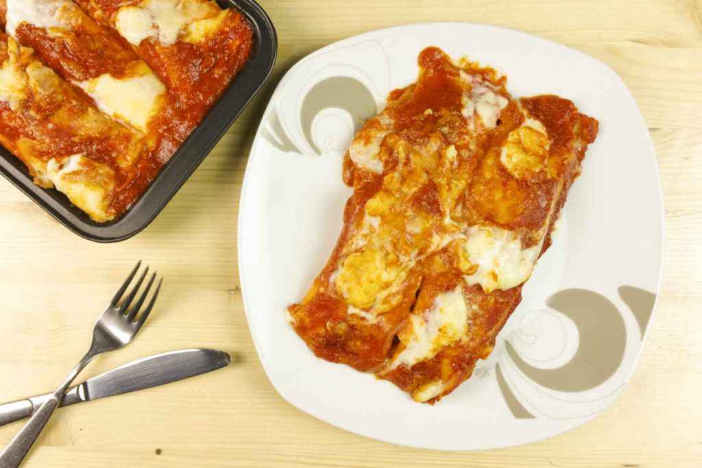 piatto con crepes ripiene di mozzarella e coperte di pomodoro