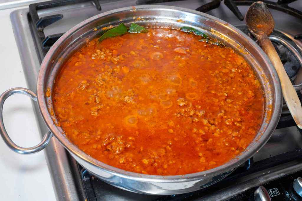 pentola sul fuoco con ragù bolognese in cottura