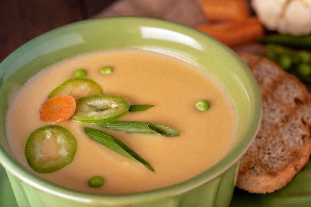 scodella con zuppa di piselli e carote