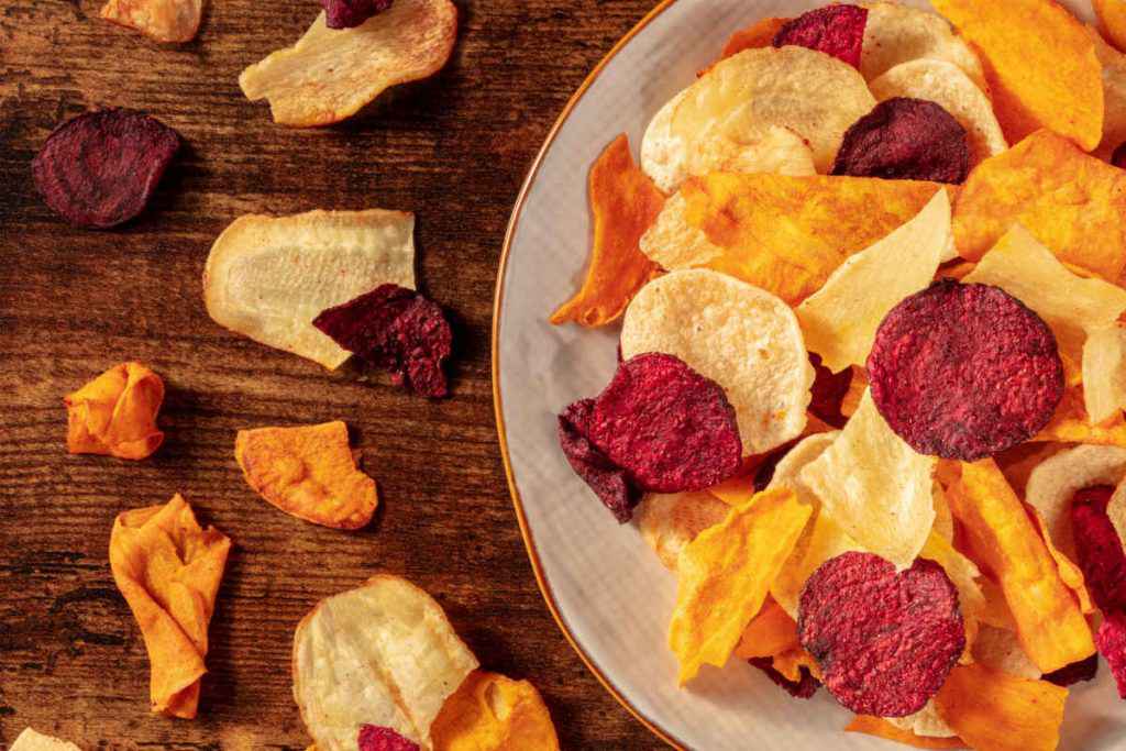 piatto con chips di verdure miste, cosa mangiare mentre si legge un libro