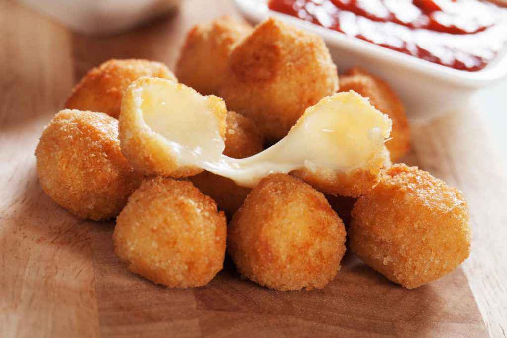 vassoio di legno con bocconcini di mozzarella impanati e fritti