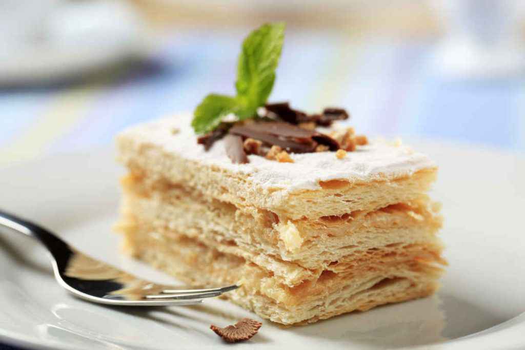 fetta di una classica torta millefoglie con riccioli di cioccolato