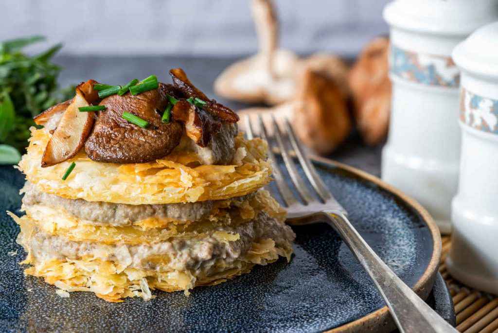 porzione di millefoglie ai funghi e crema al formaggio