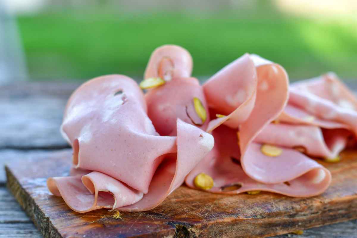 fette di mortadella ai pistacchi su tagliere di legno