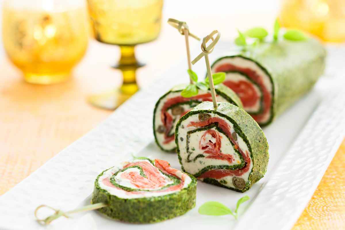 vassoio con rotolo agli spinaci, salmone e formaggio per gli antipasti natalizi