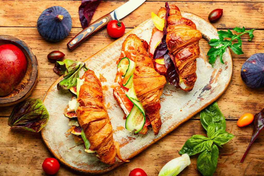 tagliere di croissant e cornetti salati farciti con verdure e altri ingredienti