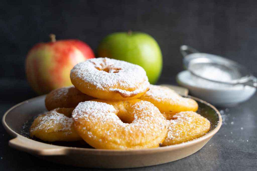 vassoio con frittelle di mele spolverate di zucchero a velo