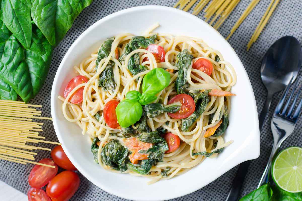 piatto di pasta con pomodorini e spinaci