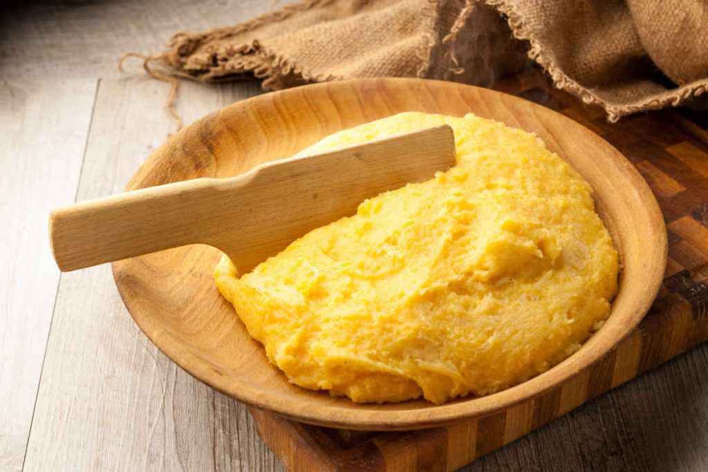 piatto di legno con polenta di farina di mais