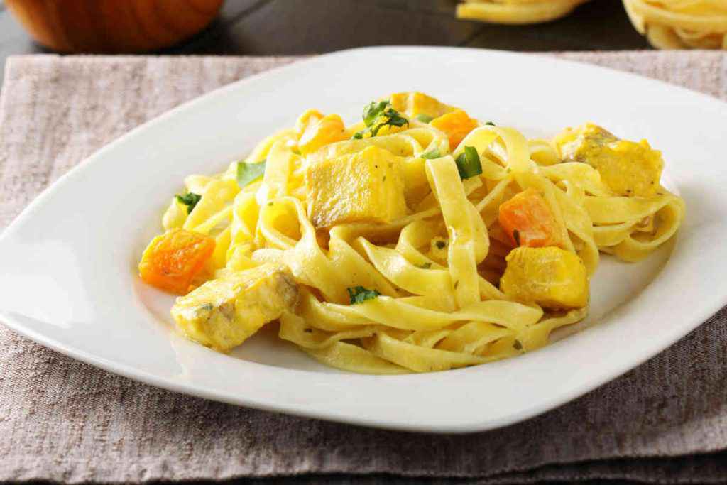 piatto di tagliatelle condite con pezzi di pesce spada allo zafferano