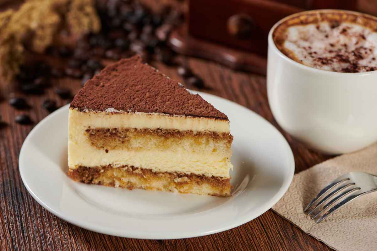 fetta di tiramisù al panettone servito con cioccolata e panna