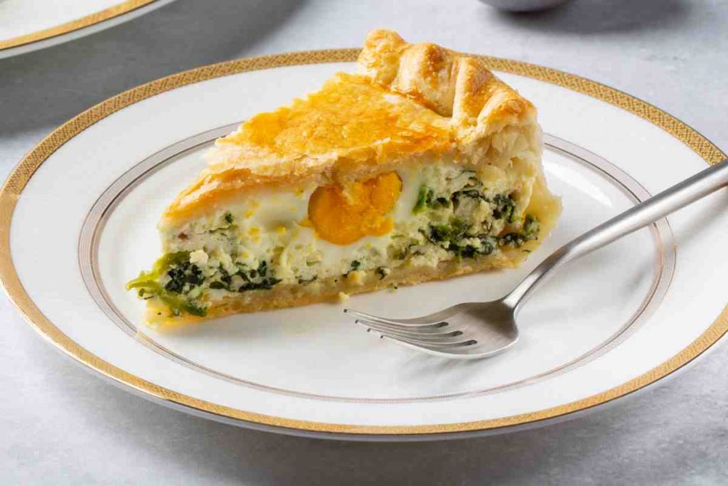 Piatto elegante con torta pasqualina con spinaci, uova e ricotta