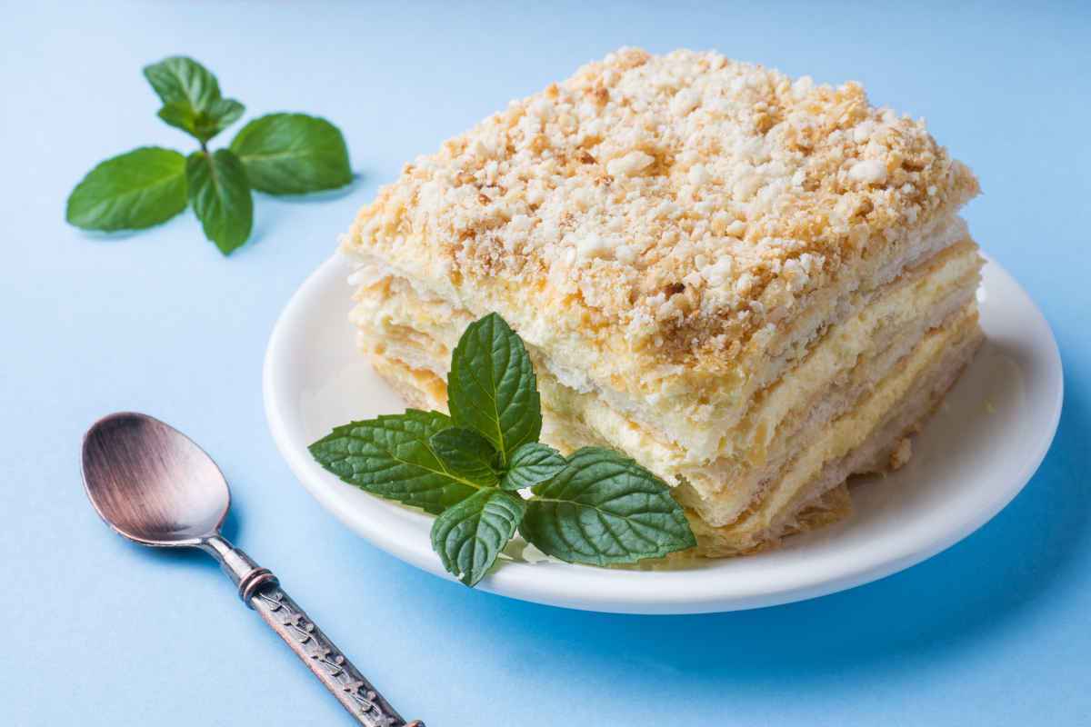 porzione di millefoglie di pandoro con crema e fogliolina di menta