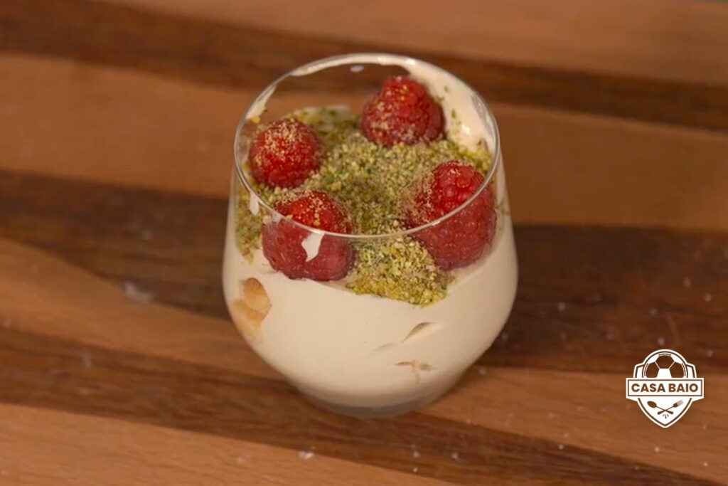 Bicchiere di vetro con Tiramisu pistacchio e lamponi