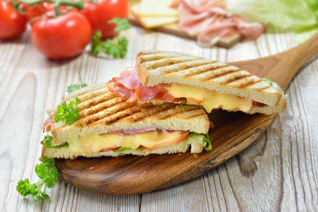 pala in legno con toast farcito e passato alla piastra