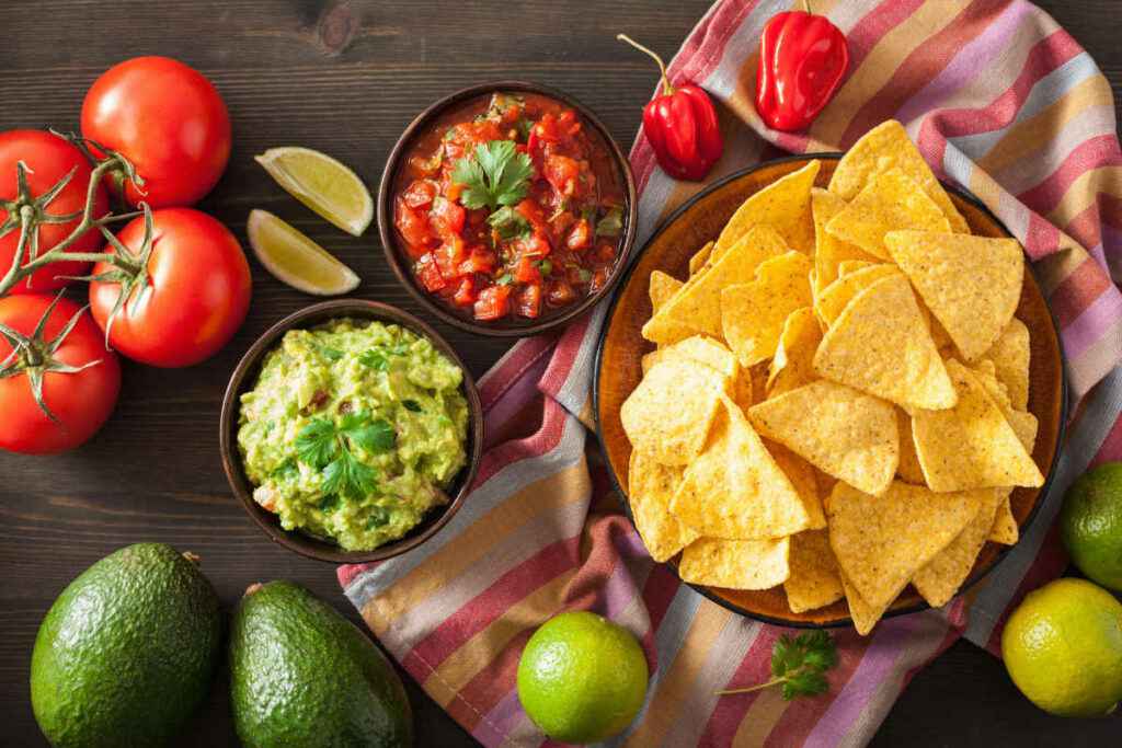 ciotole con guacamole e salsa rossa e piatto con tortilla chips