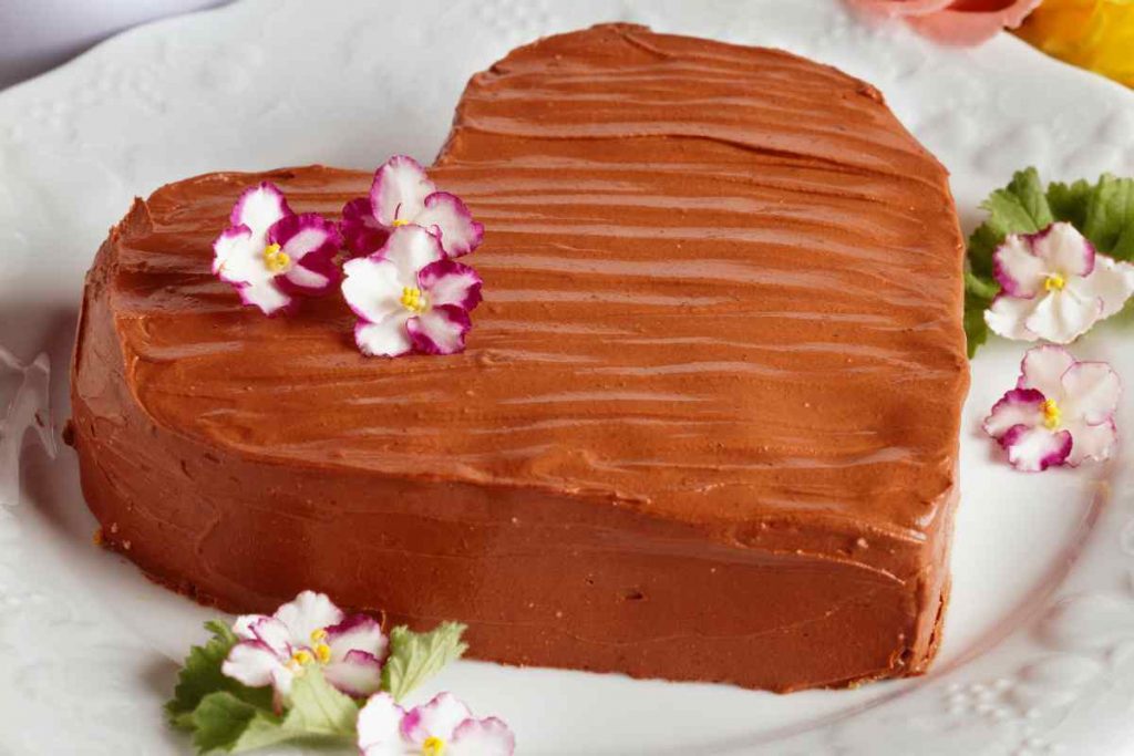 Torta cuore di cioccolato alla panna con fiorellini decorativi