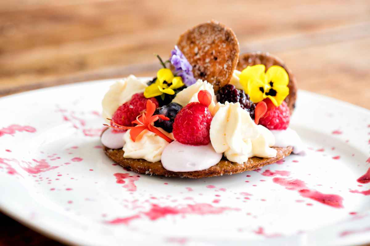 dolce con mousse e frutta con fiori edibili per dolci primaverili sfiziosi