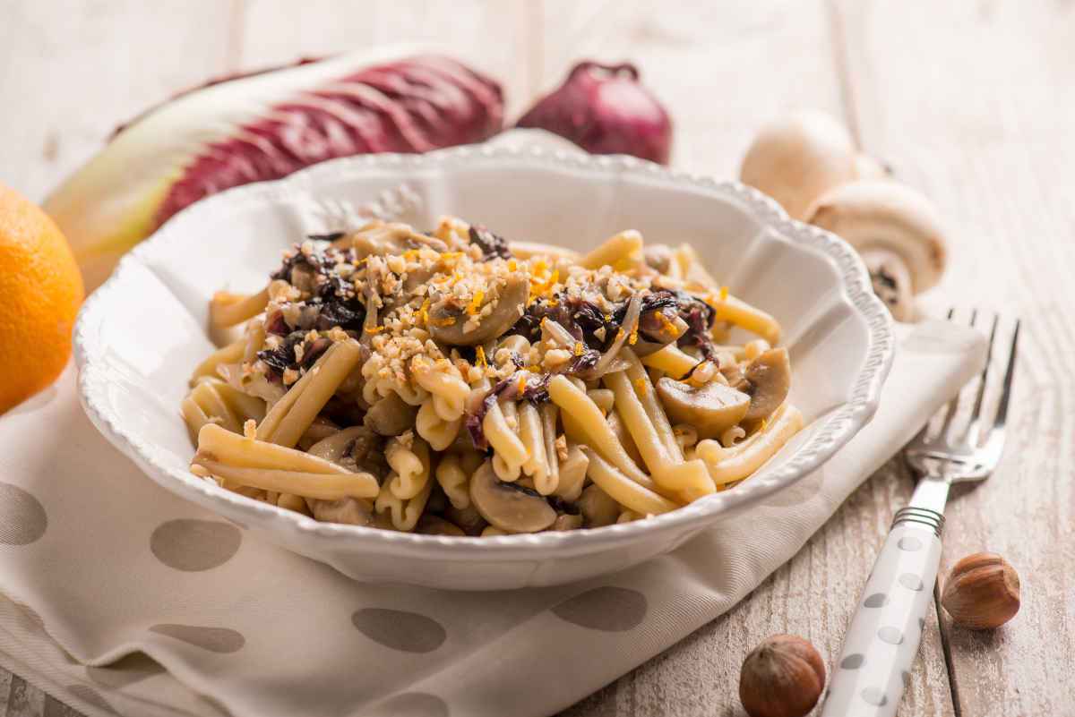 piatto di pasta con nocciole, radicchio e scorza di arancia