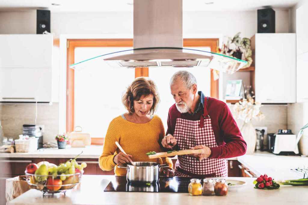 coppia ai fornelli prepara la ricetta del giorno