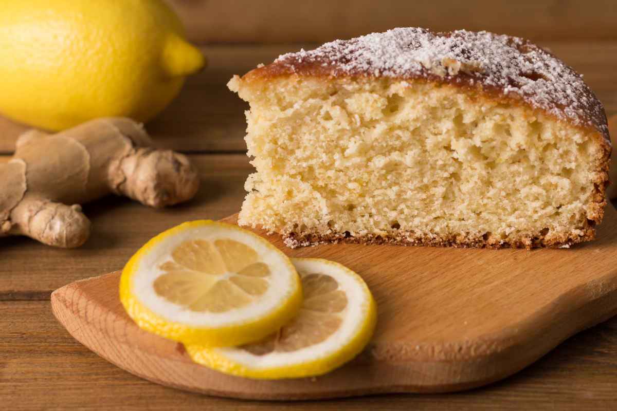 fetta di torta allo zenzero e fette di limone su tagliere di legno