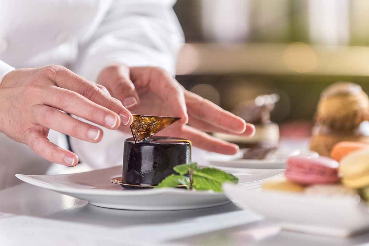 Chef pasticcere che decora una torta di cioccolato