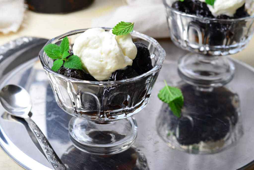 coppe di dessert con prugne al tè e panna montata