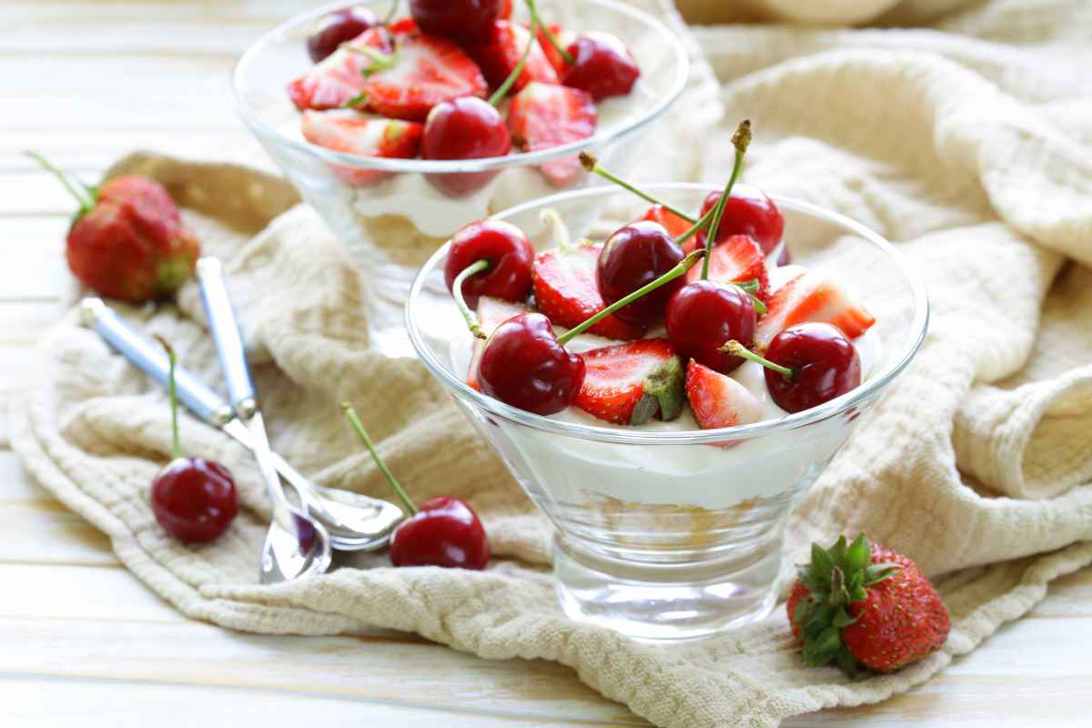 due coppe di vetro con dolce allo yogurt e frutta