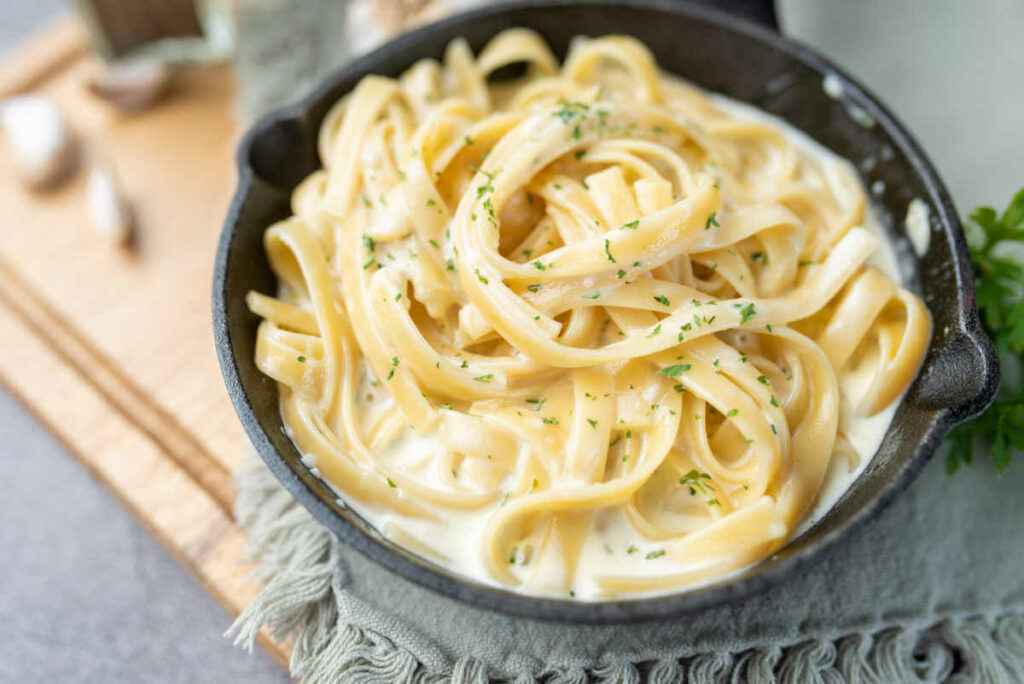 padella con fettuccine alfredo al burro, panna e formaggio