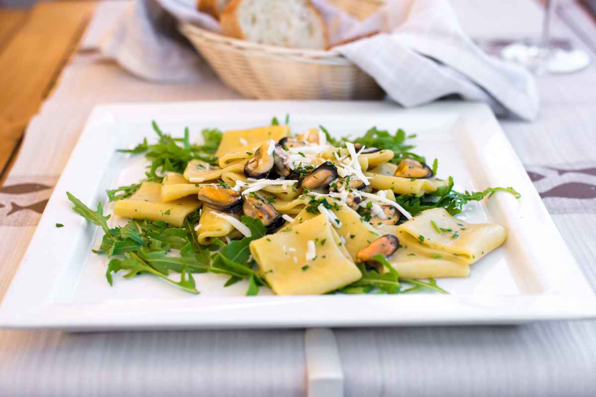 piatto quadrato con paccheri conditi con cozze e rucola