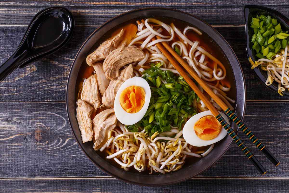 ciotola nera con ramen e bacchette di legno