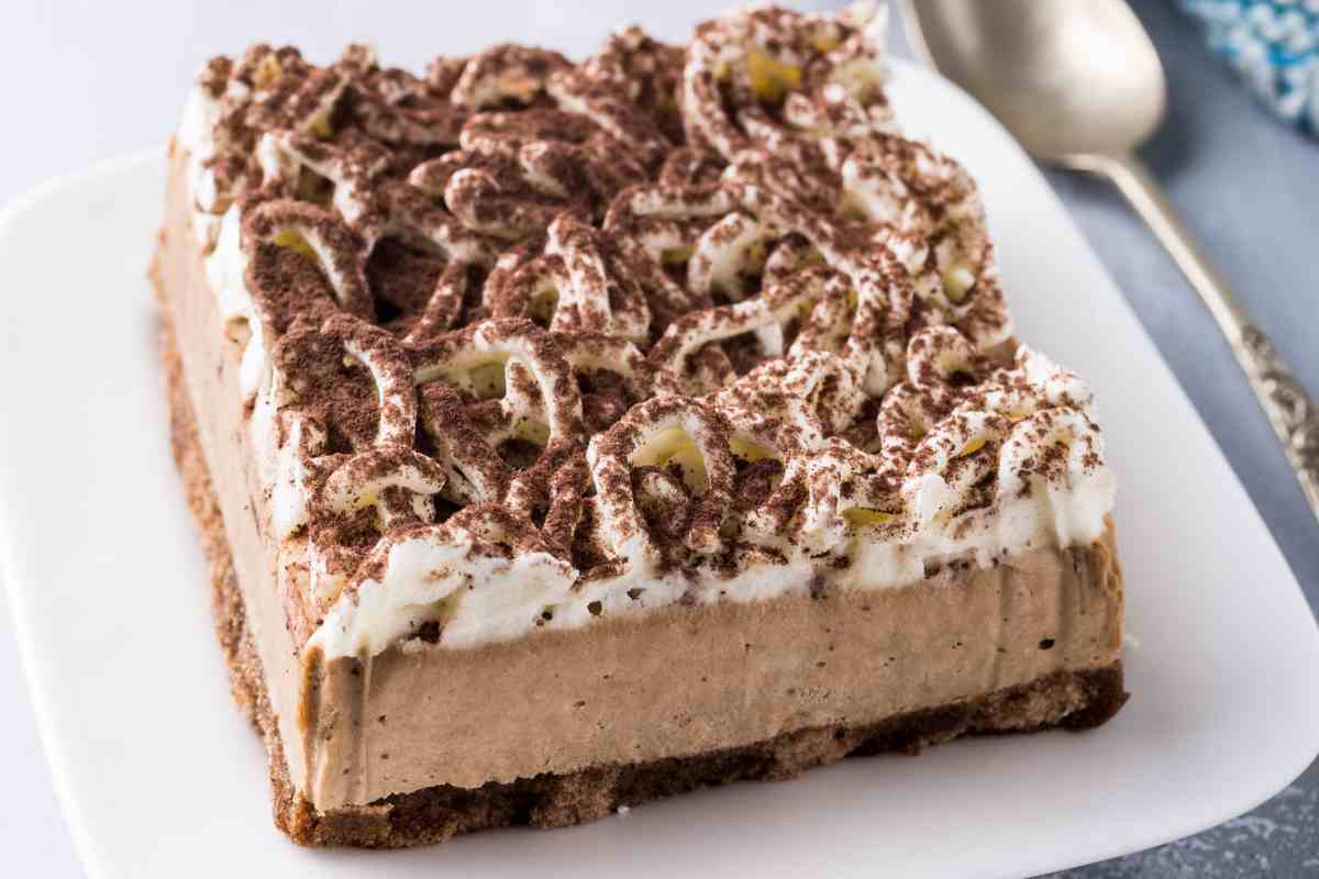 piatto quadrato con porzione di semifreddo alla Nutella, panna e topping di cioccolato