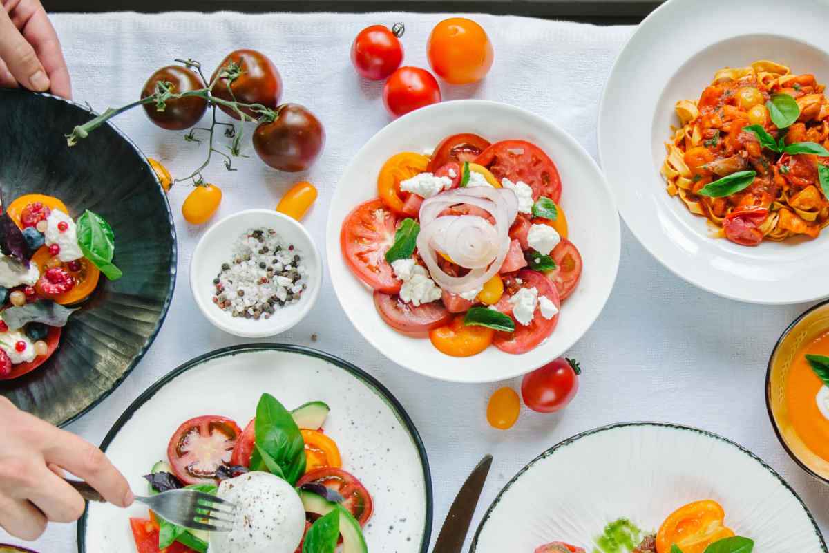 tavola imbandita con tanti piatti di verdure per la cena estiva vegetariana