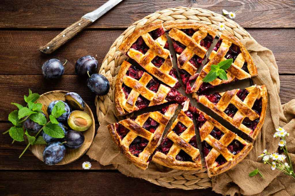 centrotavola con crostata di prugne fresche tagliata in spicchi