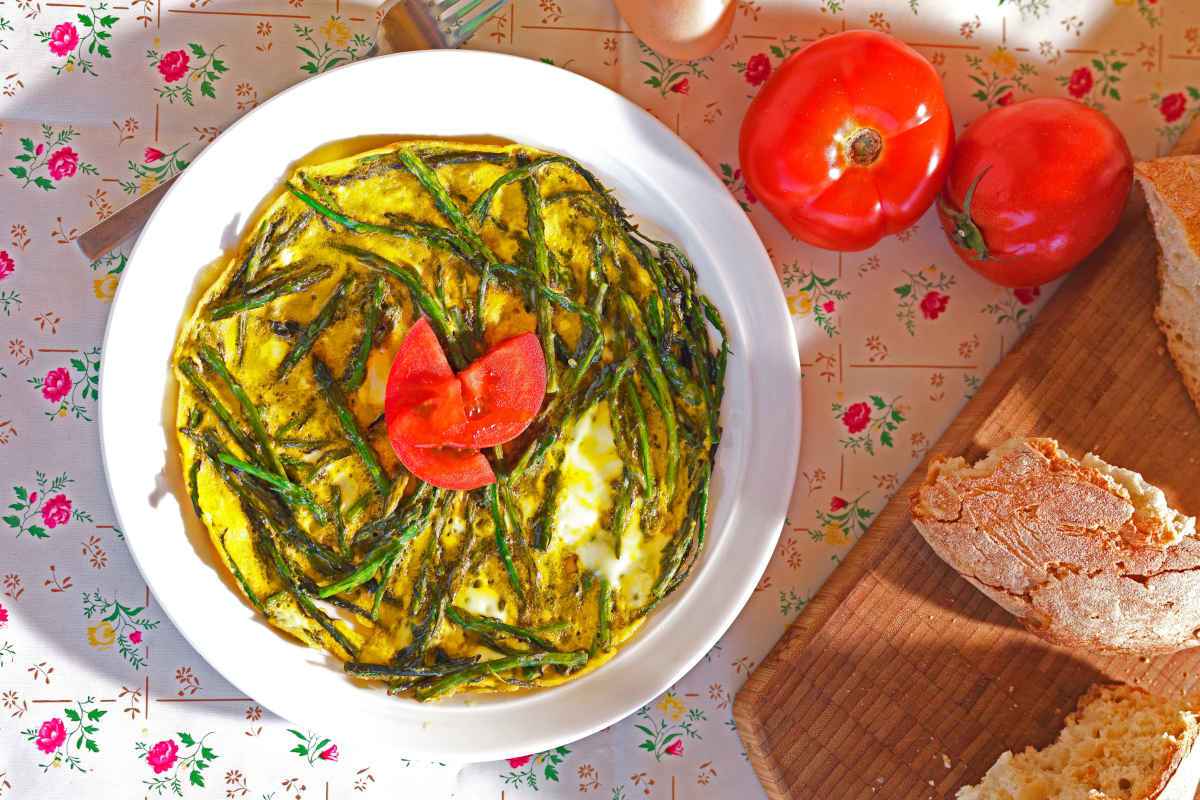 piatto con frittata di asparaginia e pomodori ramati a fettine