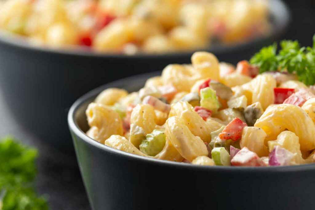 ciotole con insalata di pasta fredda con maionese