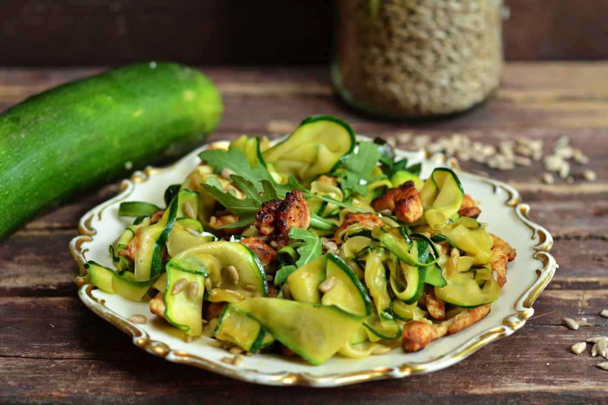 piatto decorato con pezzi di petto di pollo e zucchine saltati in padella