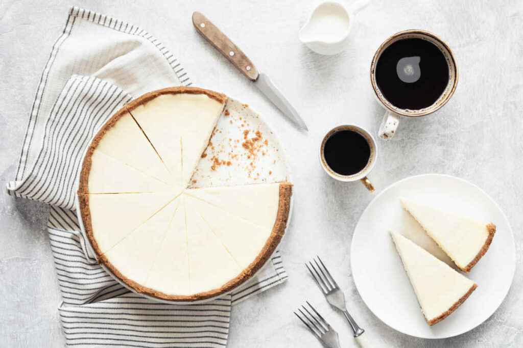 veduta dall'alto di piatto con torta fredda allo yogurt a fette e tazze di caffè