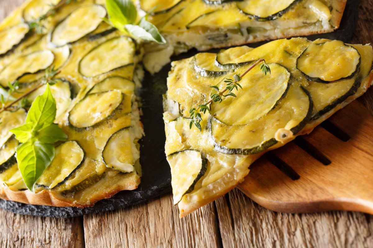 tagliere con fette di torta salata con zucchine e basilico