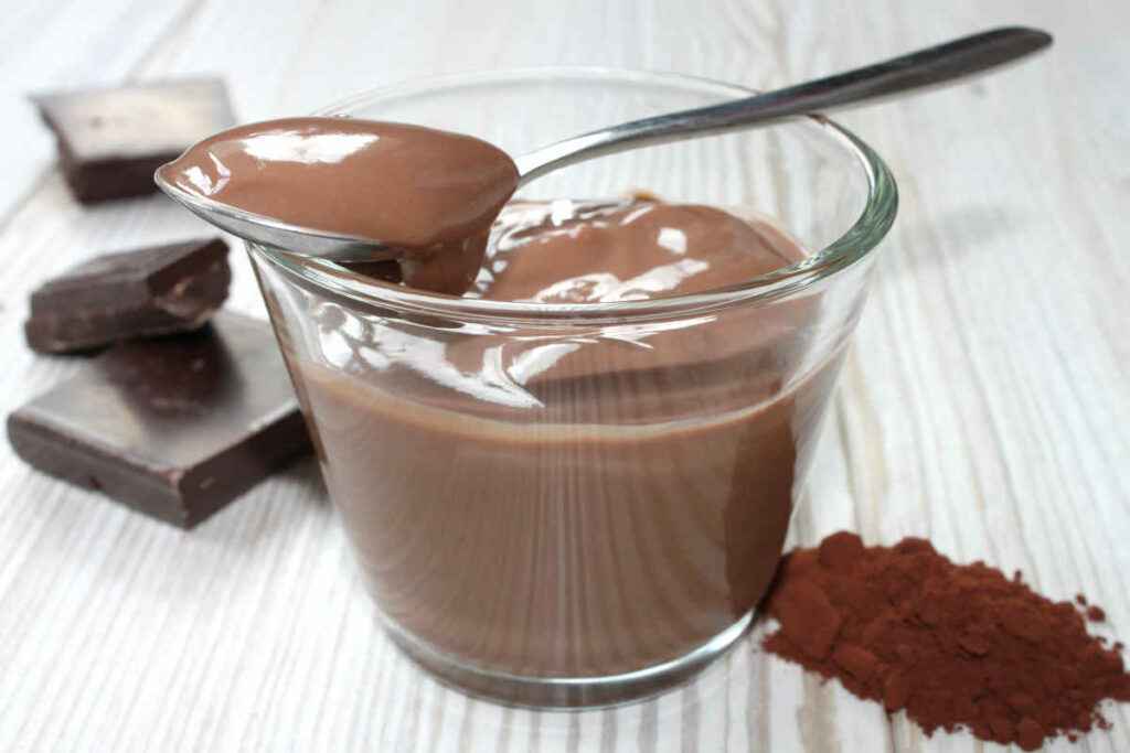ciotola in vetro con budino proteico al cioccolato fatto con preparato in polvere
