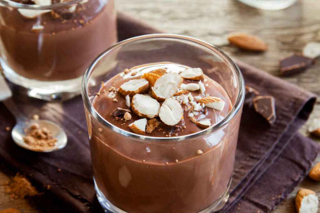 bicchieri con budino proteico al cioccolato decorato con mandorle