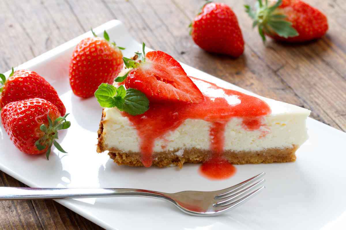 porzione di cheesecake light con salsa di fragole su piatto rettangolare