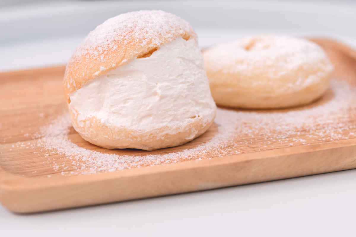 brioche fiocchi di neve ripieni di crema alla panna montata su tagliere