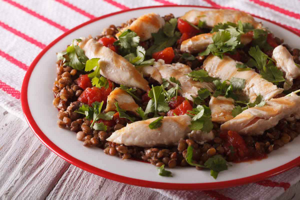 piatto con insalata di lenticchie e straccetti di pollo con pomodoro