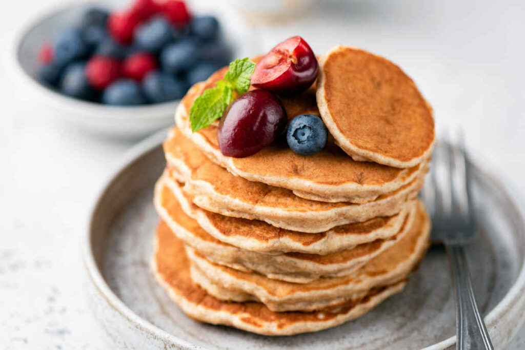 piatto grigio con torretta di pancake proteico Bimby e frutta fresca per ricette fit