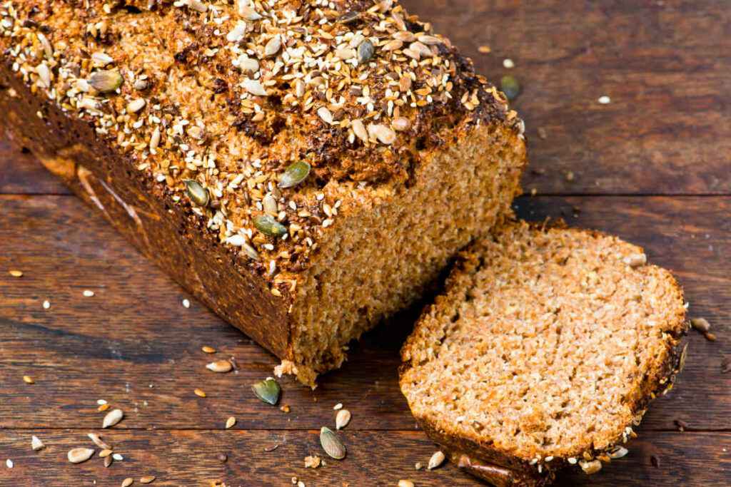 tagliere di legno con pane proteico tagliato a fette per ricette fit