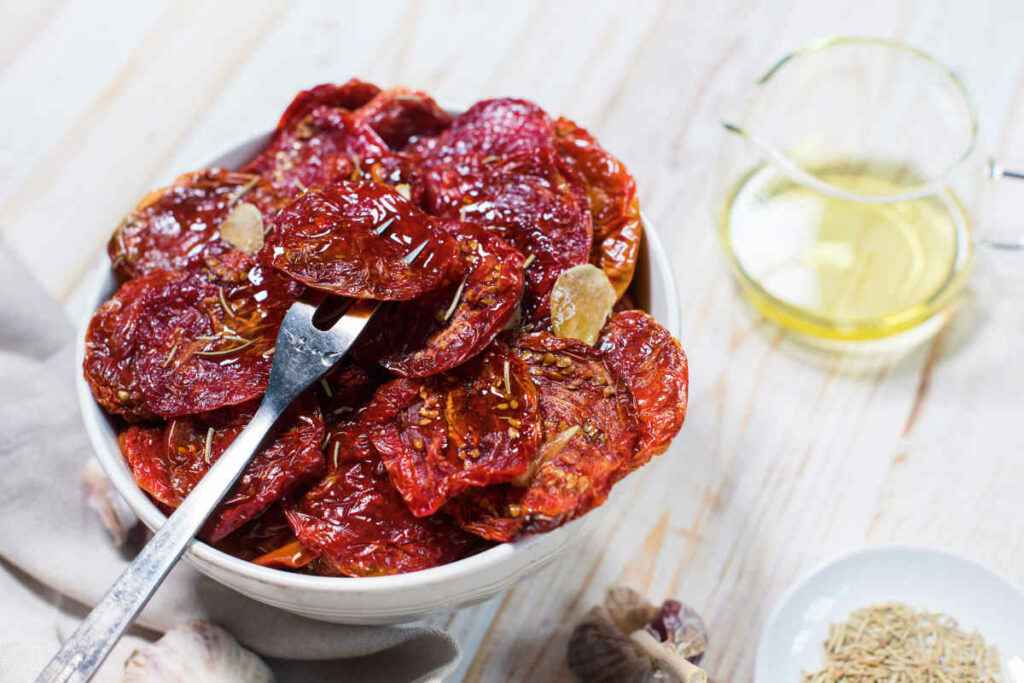 ciotola con pomodori secchi sott'olio conditi con aglio e origano