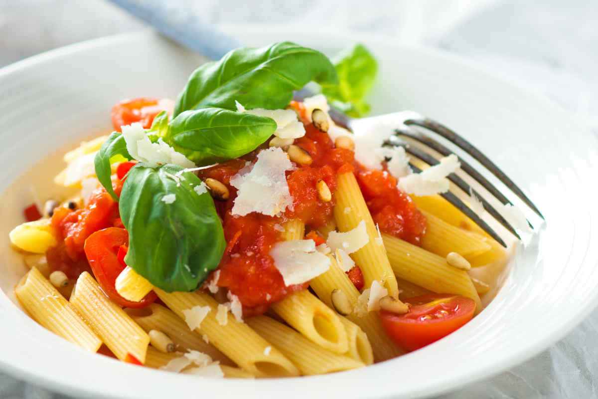 primi piatti di pasta con pomodori freschi, basilico e pinoli
