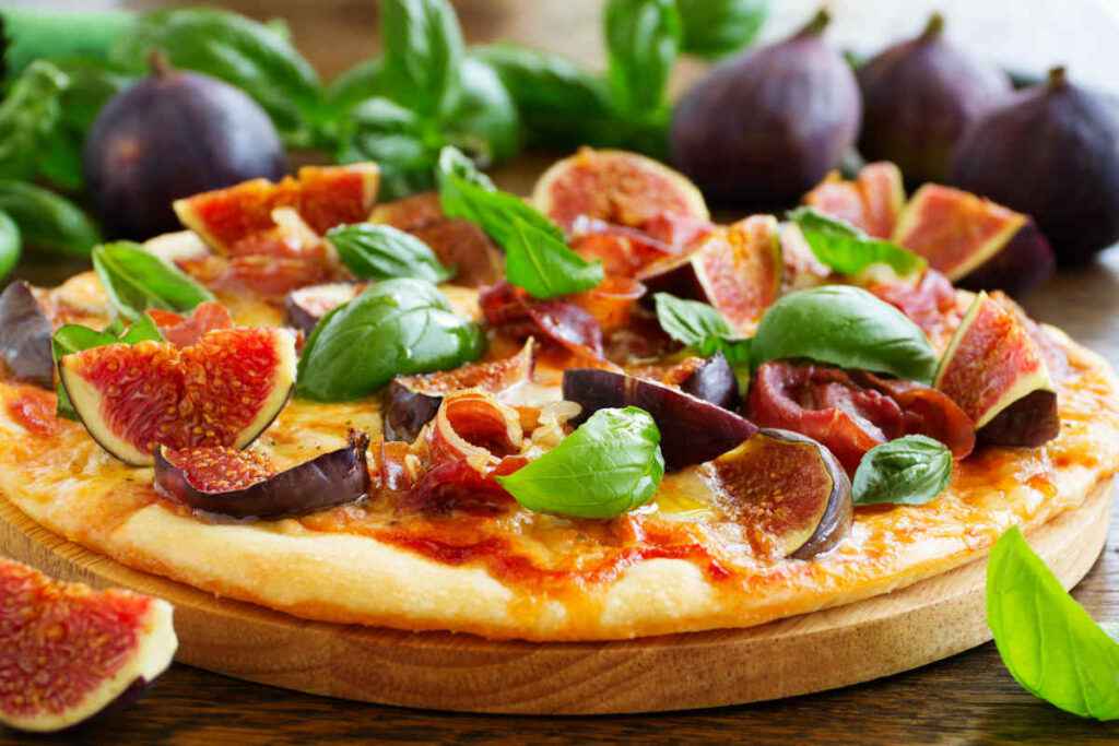pizza e fichi su tagliere di legno per ricette salate con frutta